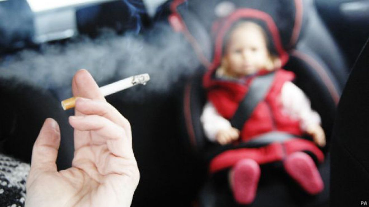 Un fumador con un niño en el coche