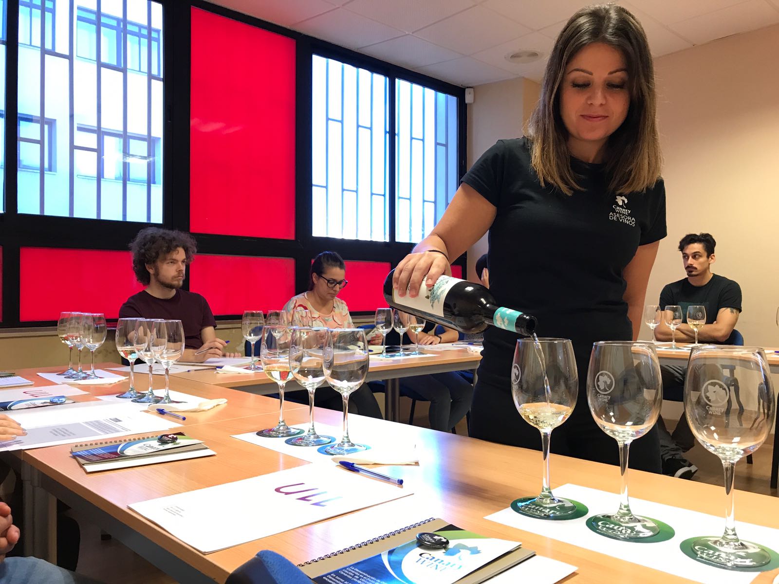 una mujer sirviendo copas de vino