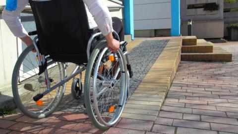Una persona en silla de ruedas subiendo una rampa