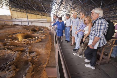 Un grupo de visitantes en el yacimiento arqueológico de la Cueva Pintada