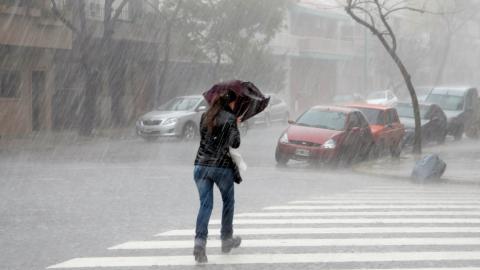 Una mujer con un paraguas caminando por la calle