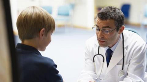 Niño en consulta con pediatra Pediatra con niño